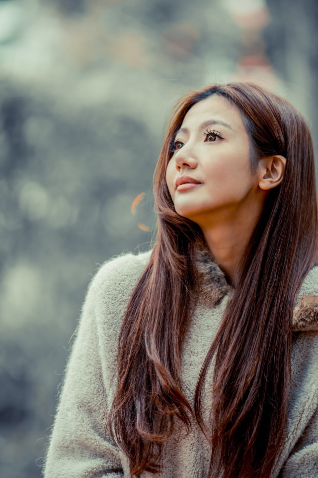 Длинноволосая девушка азиатка смотрит в сторону