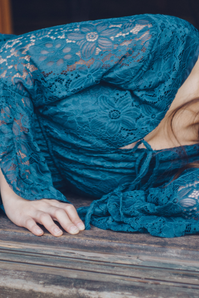 Красивая девушка азиатка в платье лежит на полу