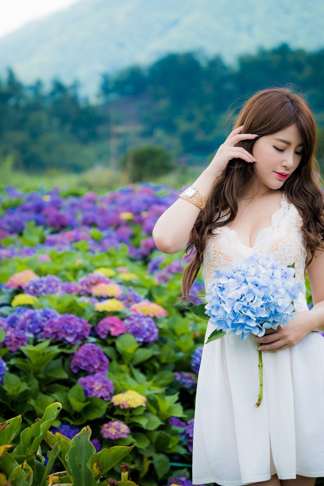 Красивая девушка азиатка в белом платье с цветами гортензии 