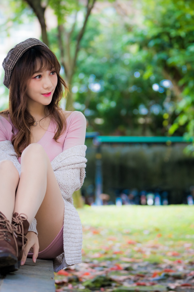 Красивая девушка азиатка сидит на земле 