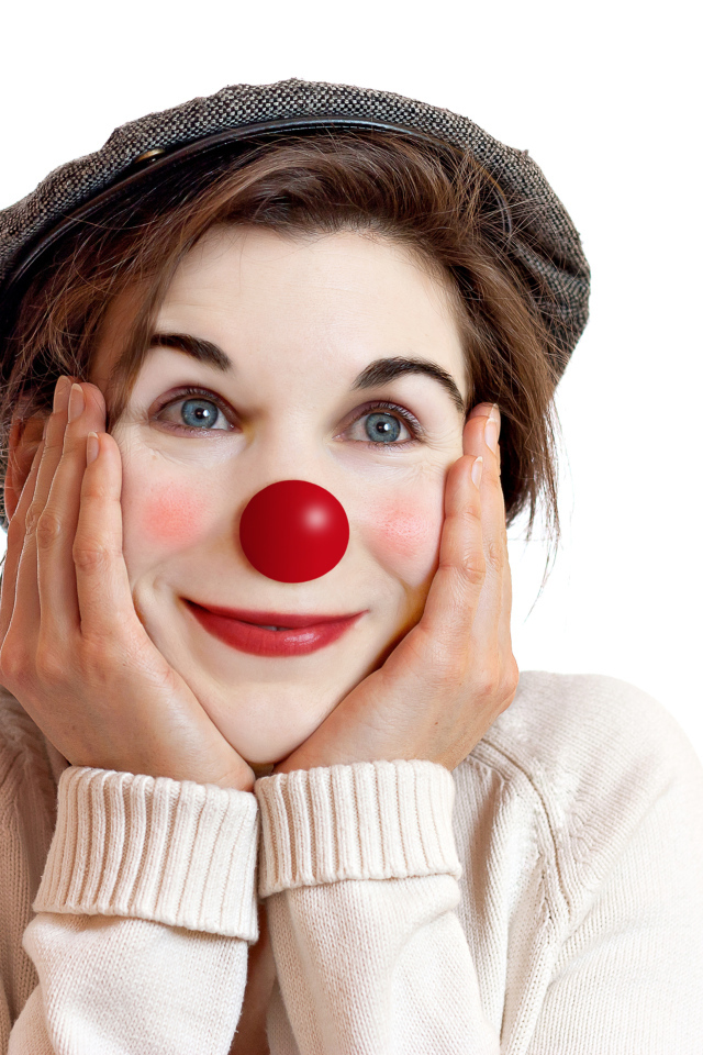 Красивая голубоглазая девушка в кепке с носом клоуна на белом фоне