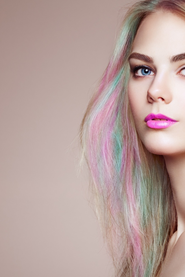 Красивая голубоглазая девушка с разноцветными волосами на сером фоне