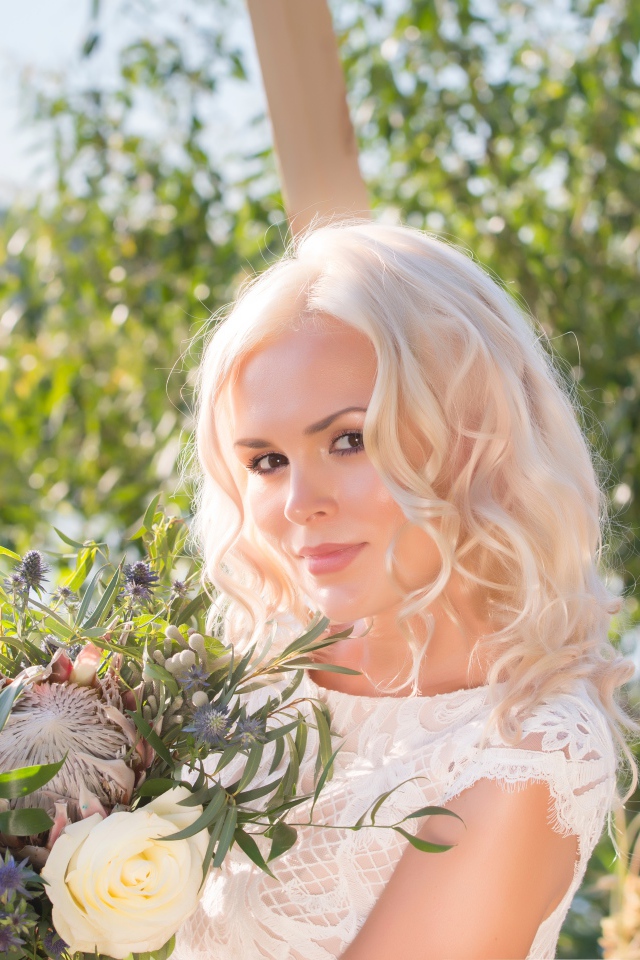 Красивая кареглазая блондинка с букетом в руках 