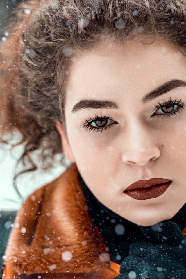 Красивая кареглазая девушка стоит на улице зимой