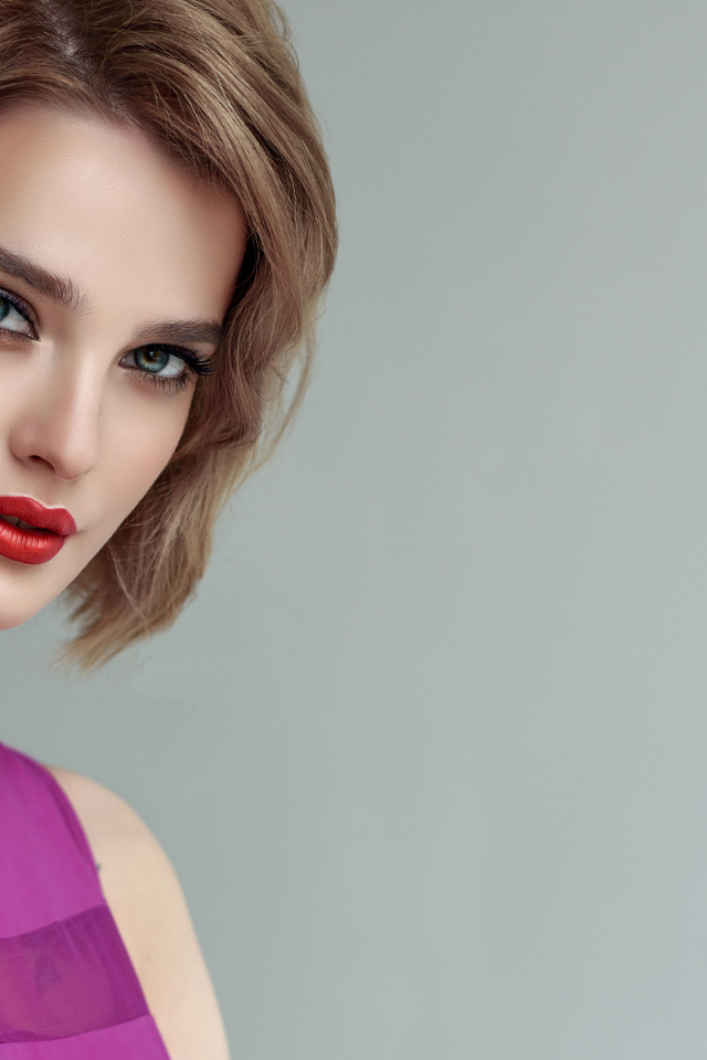 Красивая девушка шатенка с короткой стрижкой на сером фоне