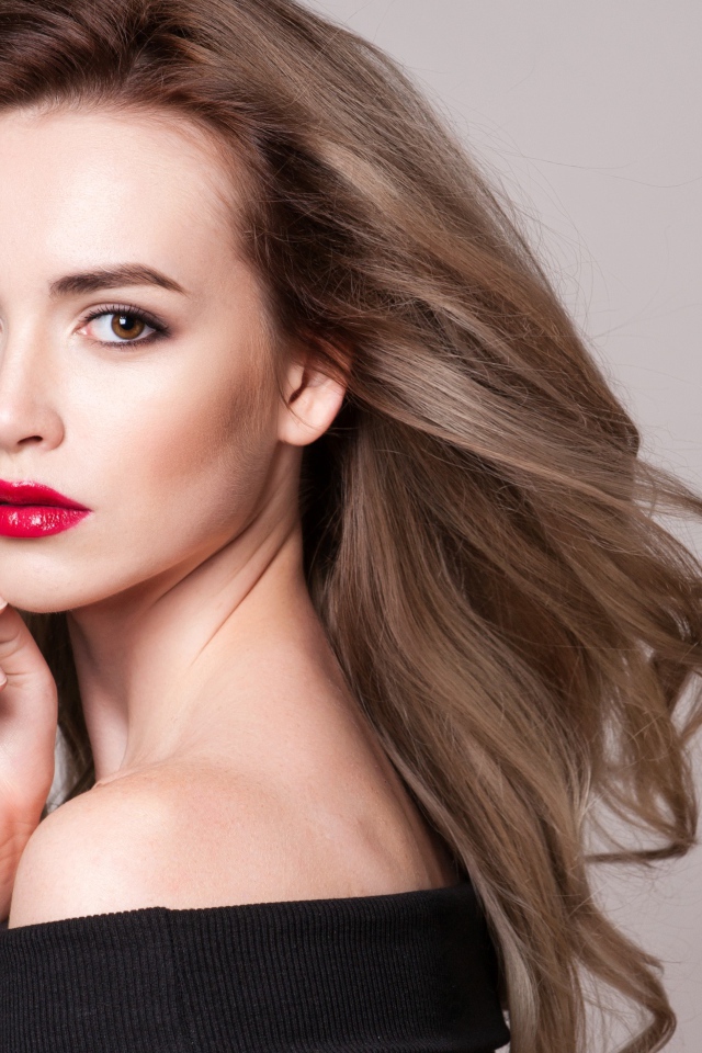 Красивая шатенка с красными губами на сером фоне