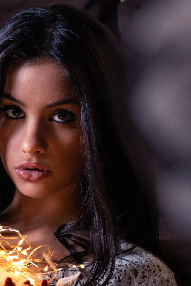 Красивая брюнетка с гирляндой в руках