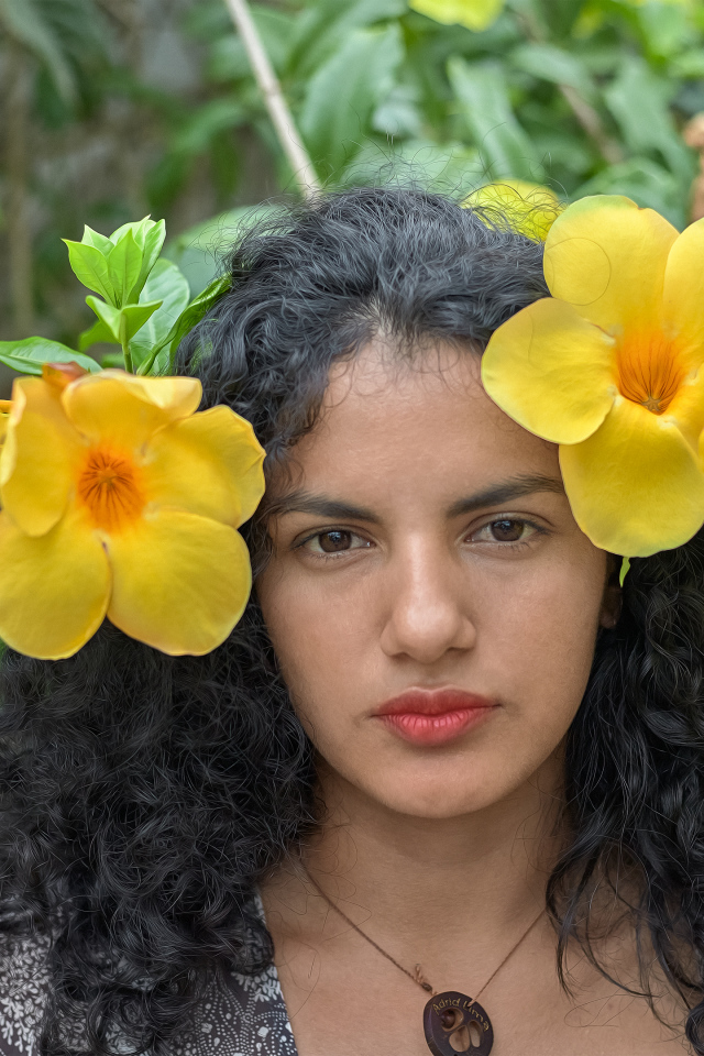 Красивая брюнетка с большими желтыми цветами в волосах 