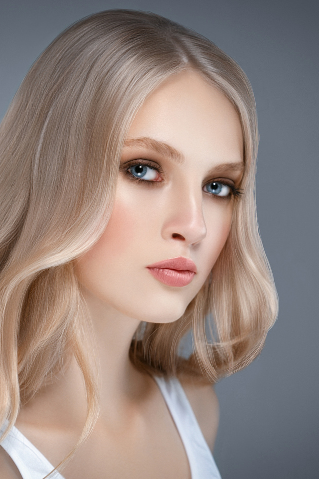 Красивая нежная голубоглазая блондинка на сером фоне