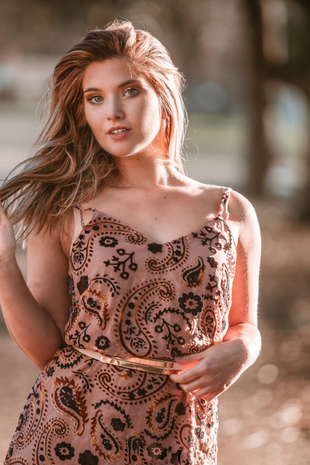 Красивая девушка в платье в лучах солнца летом