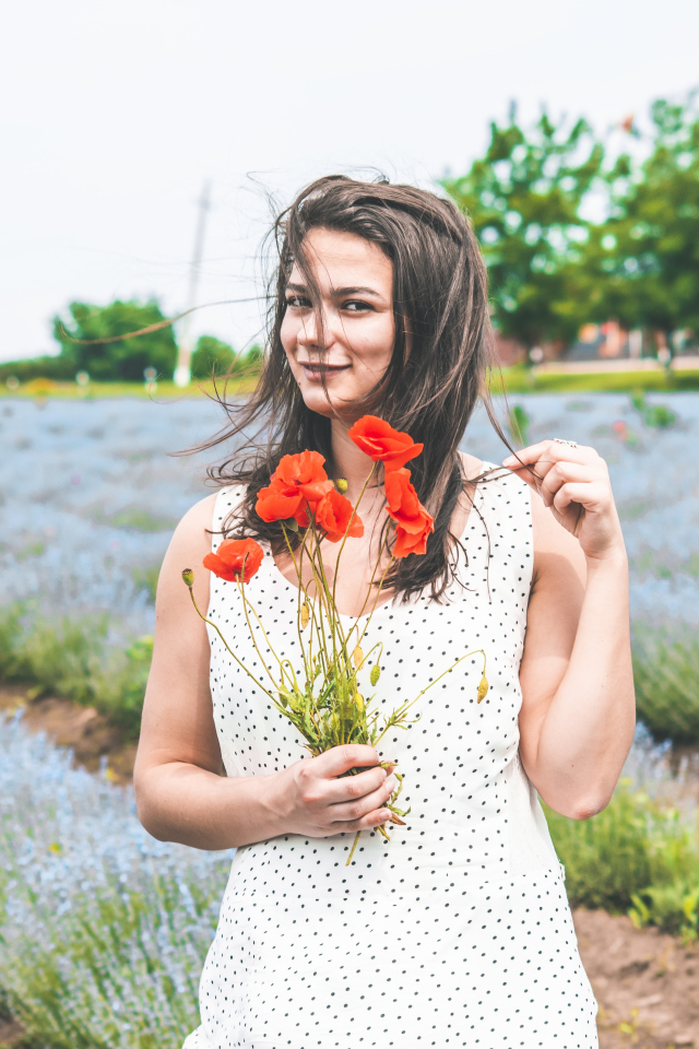 Красивая девушка в платье с букетом маков