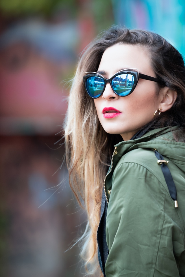 Красивая девушка в куртке и солнечных очках