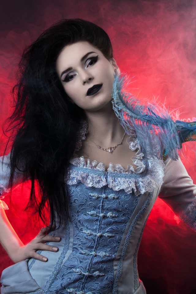 Красивая девушка в старинном платье с маской в руке