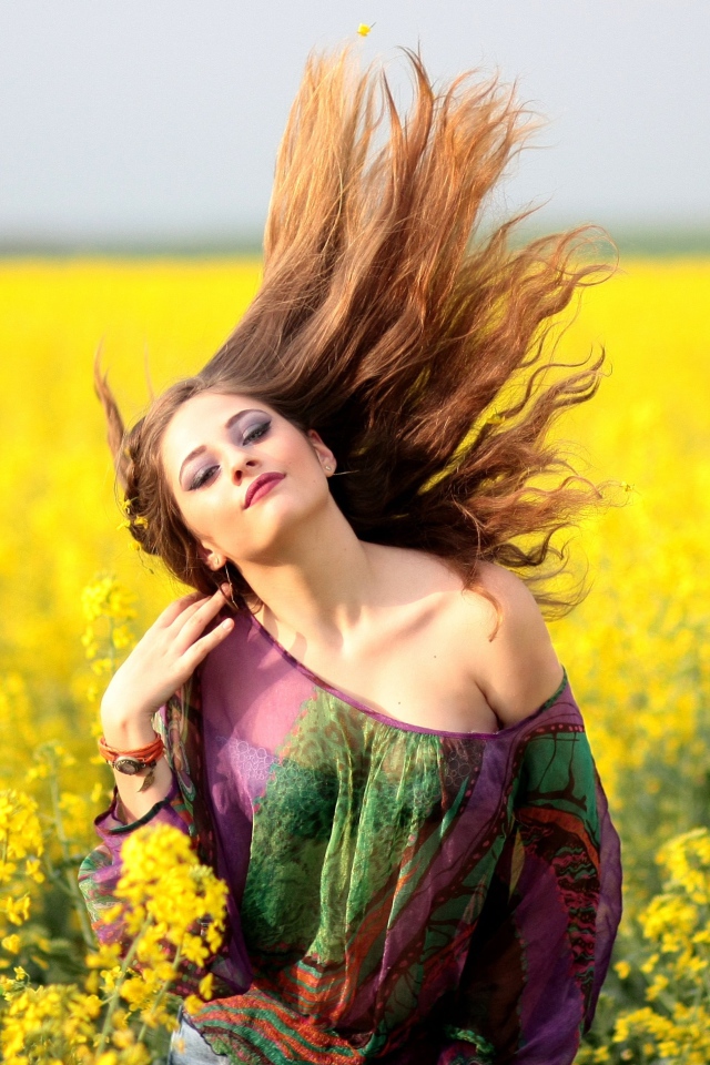 Красивая девушка на поле с желтыми цветами