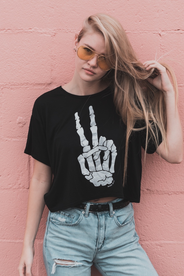 Красивая девушка стоит у розовой стены 