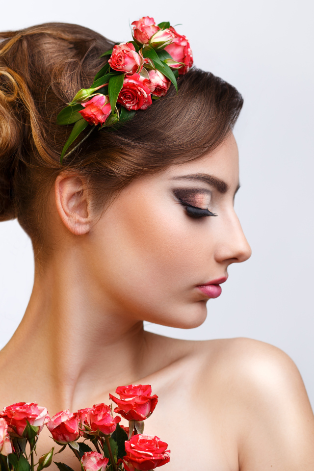 Красивая девушка с прической и венком из роз в волосах 