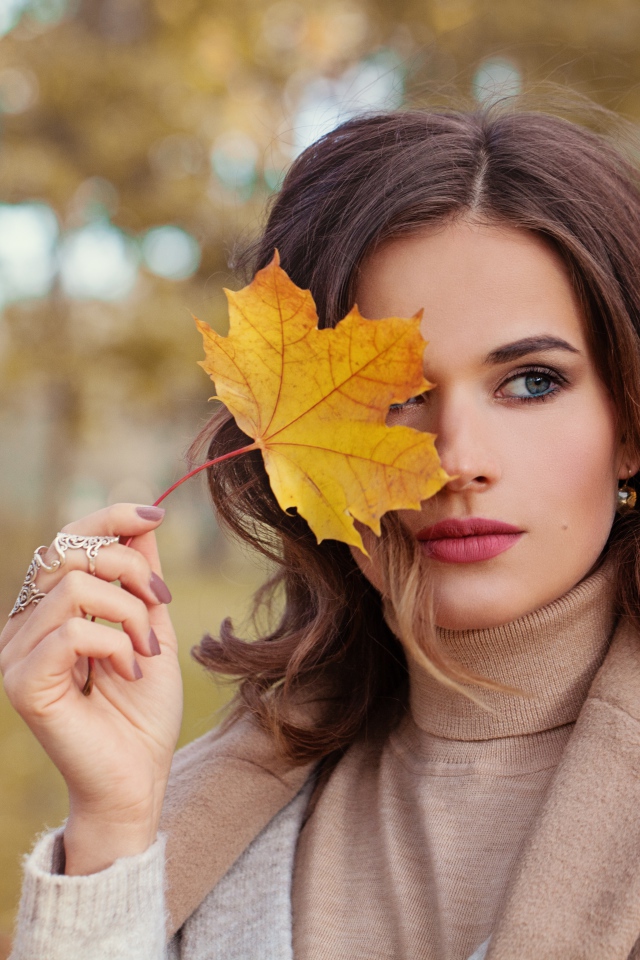 Красивая девушка с осенним листом в руке