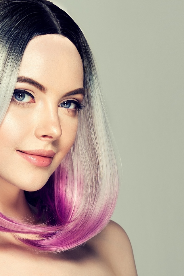 Красивая девушка с крашеными волосами на сером фоне