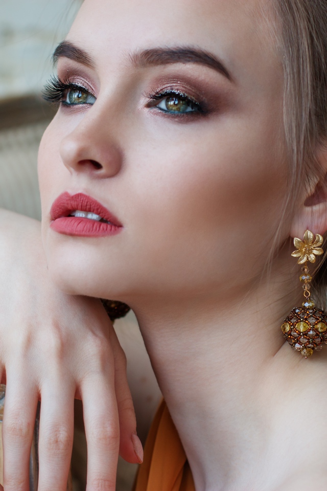 Красивая девушка с длинными ресницами с красивыми серьгами в ушах