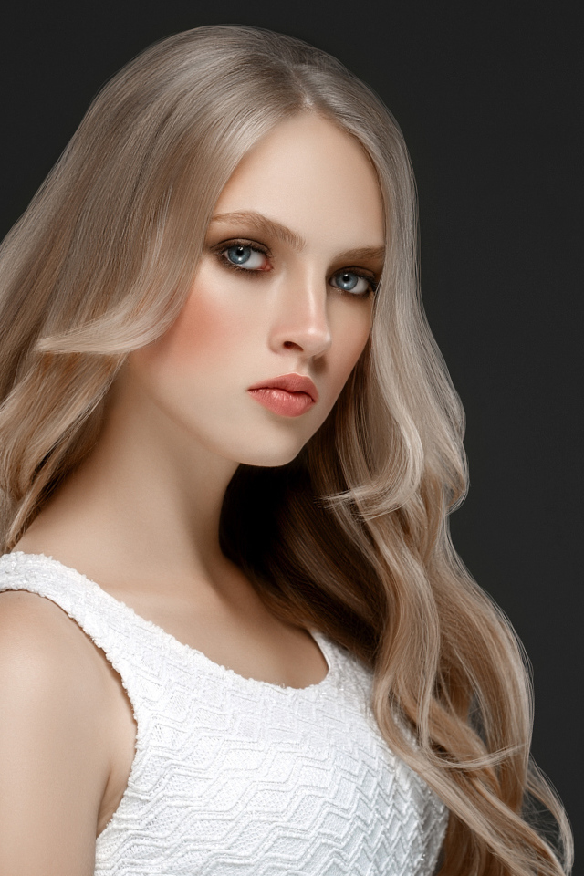 Красивая девушка с длинными  белыми волосами на сером фоне
