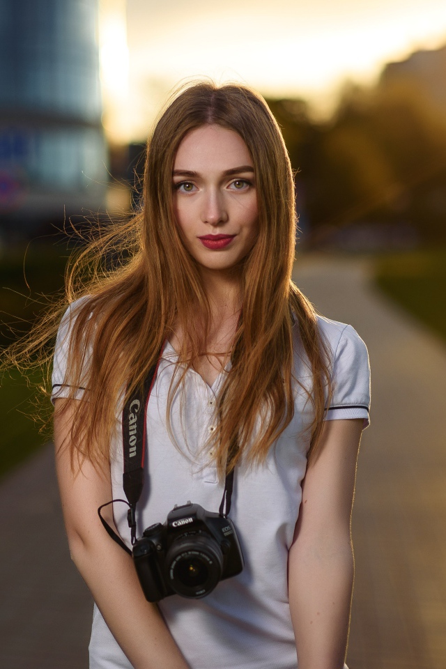 Красивая длинноволосая девушка с фотоаппаратом