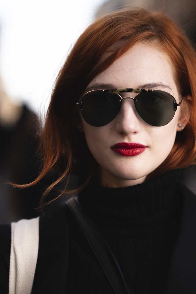 Красивая рыжеволосая девушка в темных очках