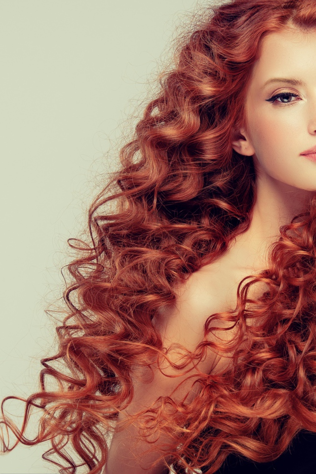 Красивая рыжеволосая девушка на сером фоне