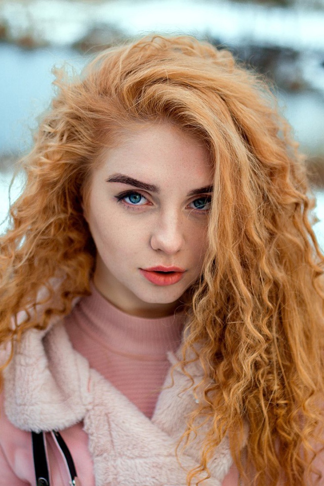 Красивая рыжеволосая девушка с голубыми глазами зимой