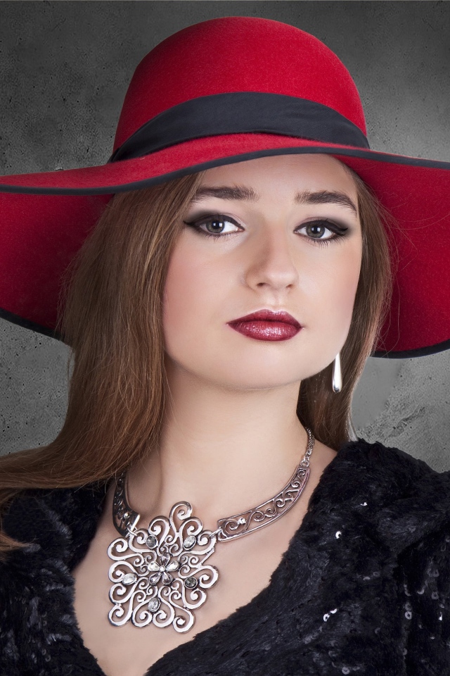 Красивая стильная девушка в красной шляпе с украшением на шее 