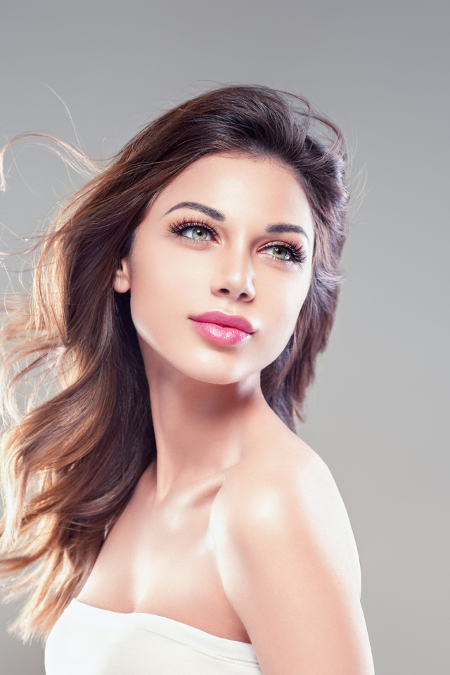 Красивая нежная девушка шатенка на сером фоне