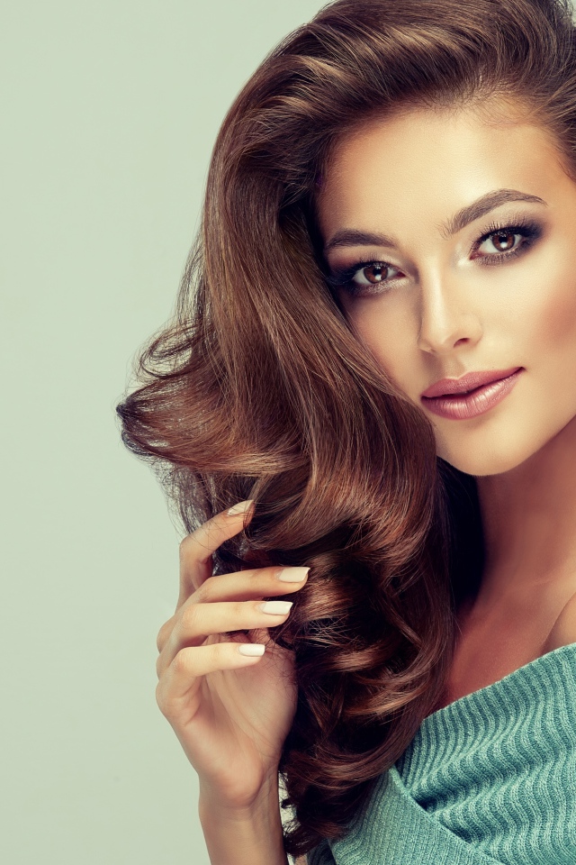 Красивая нежная девушка с длинными русыми волосами на сером фоне