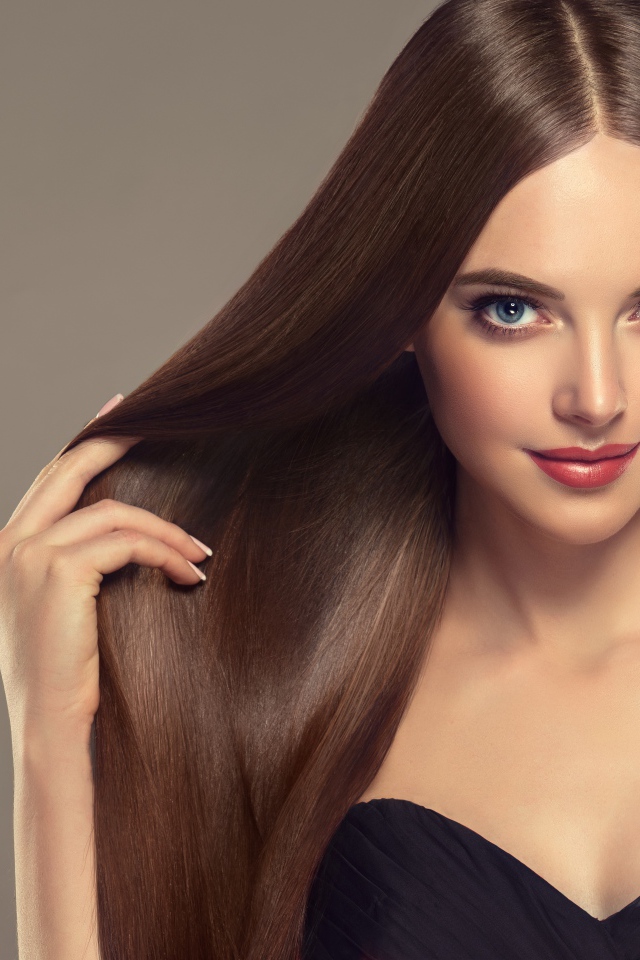 Красивая нежная длинноволосая голубоглазая девушка на сером фоне