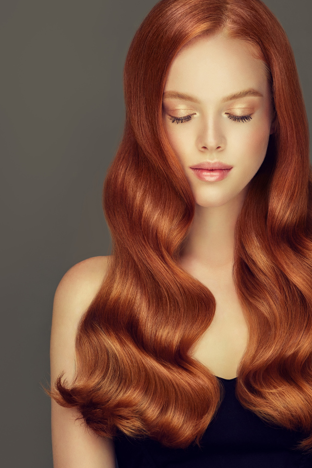 Красивая нежная рыжеволосая девушка на сером фоне