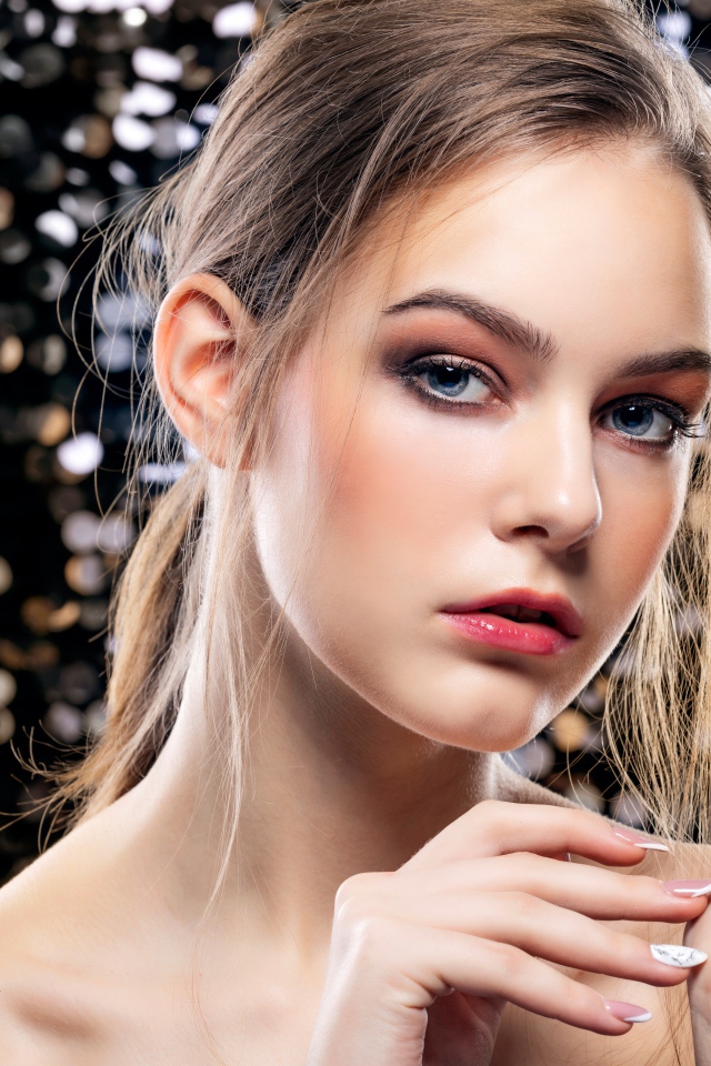 Красивая молодая голубоглазая девушка с маникюром