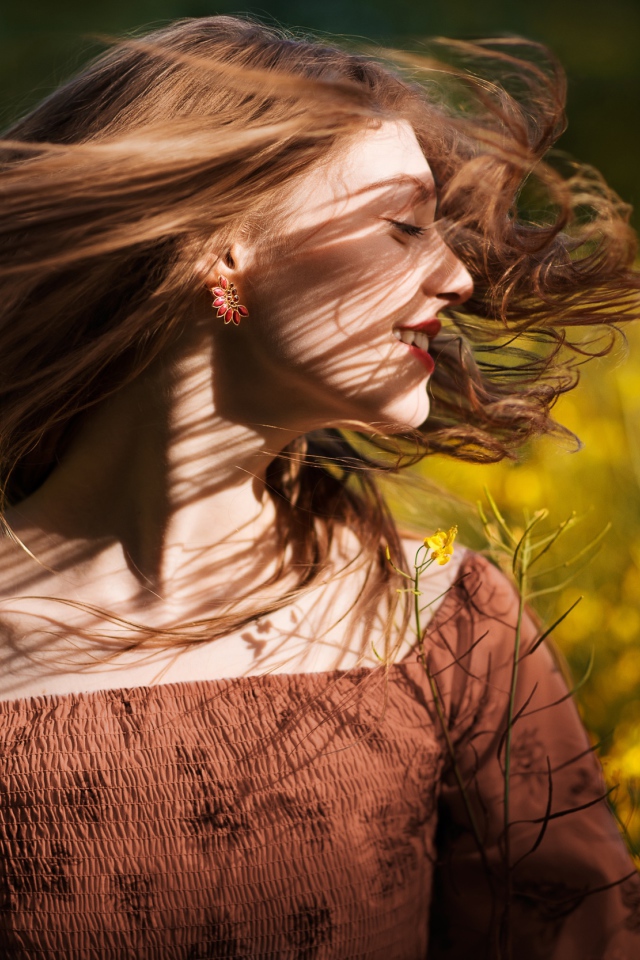 Красивая молодая девушка на поле с желтыми цветами