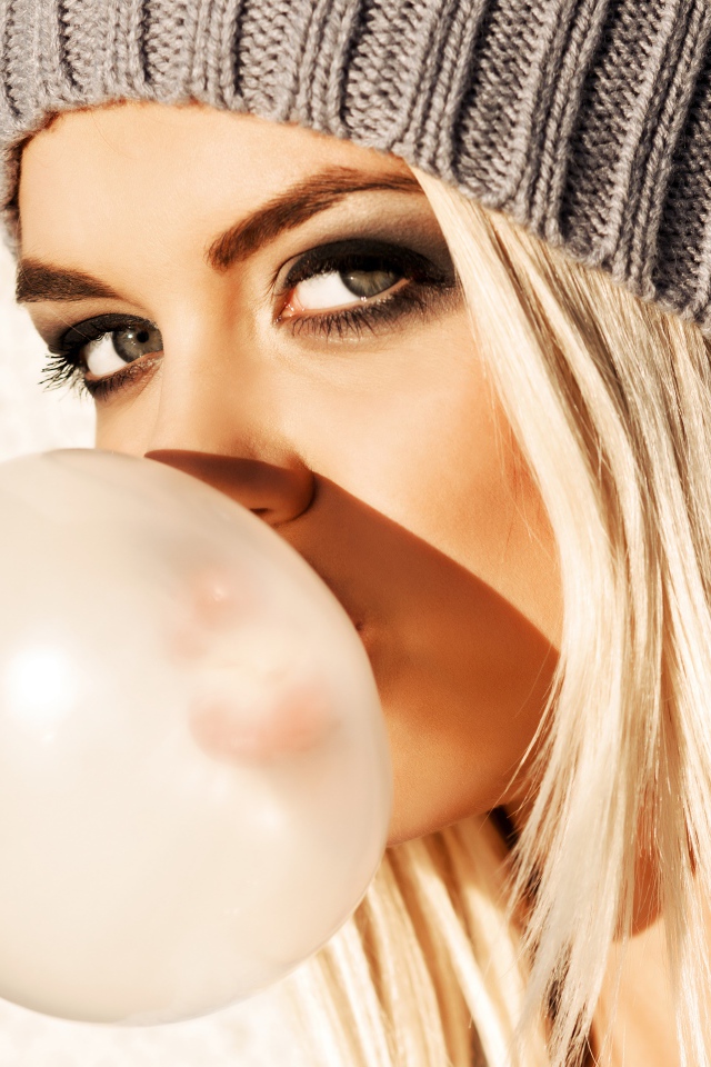 Девушка блондинка с жвачкой во рту крупным планом