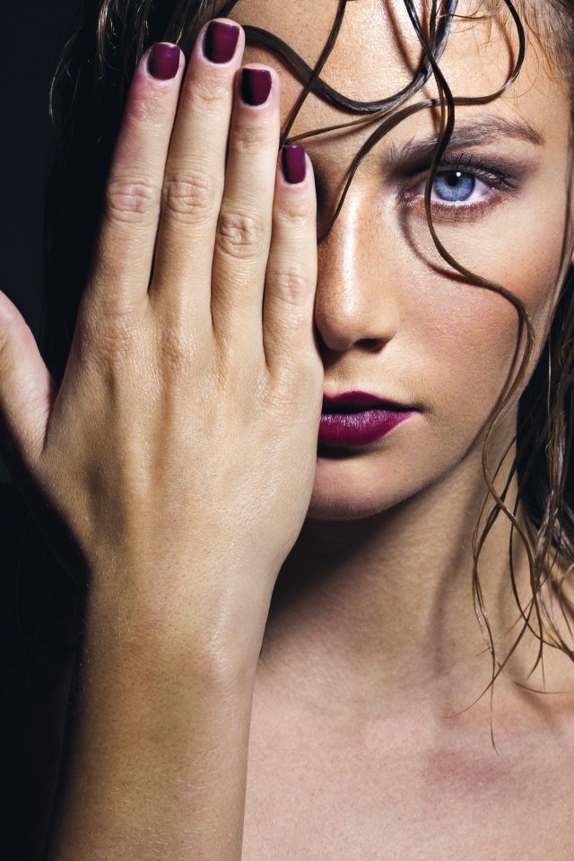 Голубоглазая девушка закрывает лицо рукой