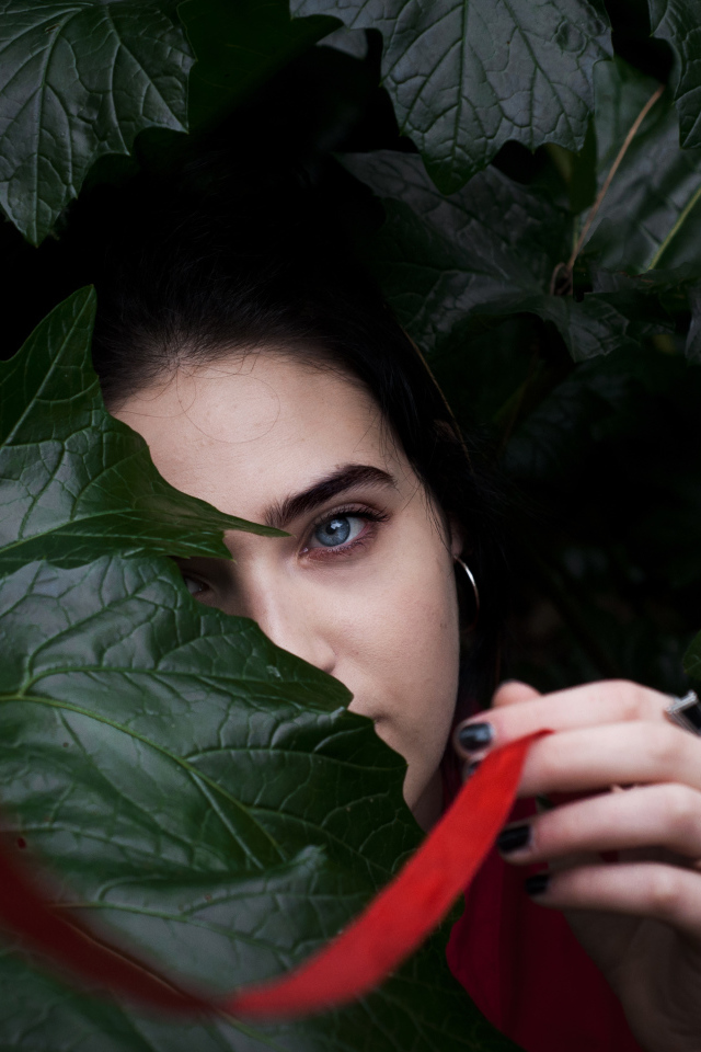Голубоглазая девушка в больших зеленых листьях