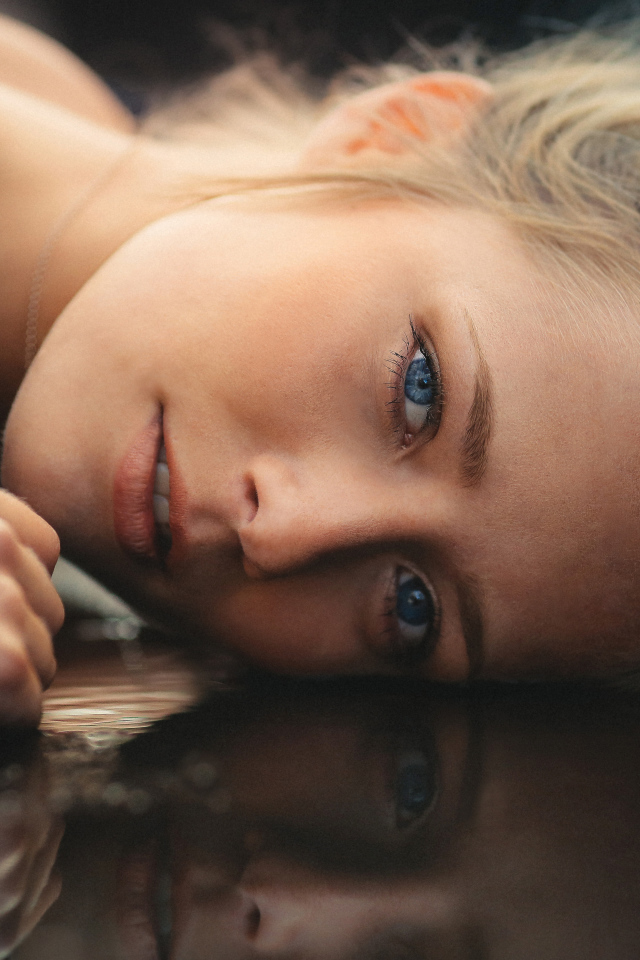 Голубоглазая девушка модель лежит на полу