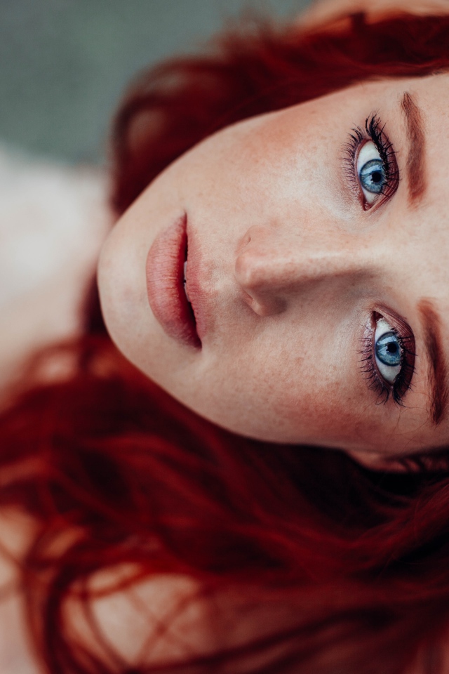 Голубоглазая рыжеволосая девушка с веснушками на лице