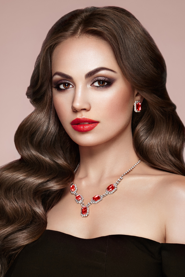 Яркая красивая девушка с украшениями на розовом фоне