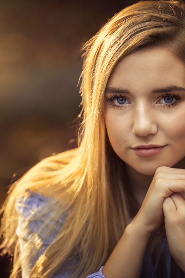 Милая голубоглазая девушка в лучах солнца