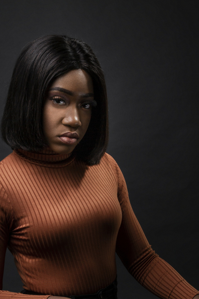 Темнокожая девушка с короткой стрижкой на сером фоне