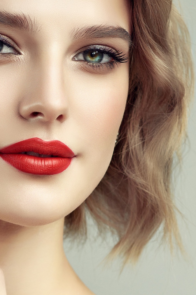 Лицо девушка с красивым макияжем на сером фоне