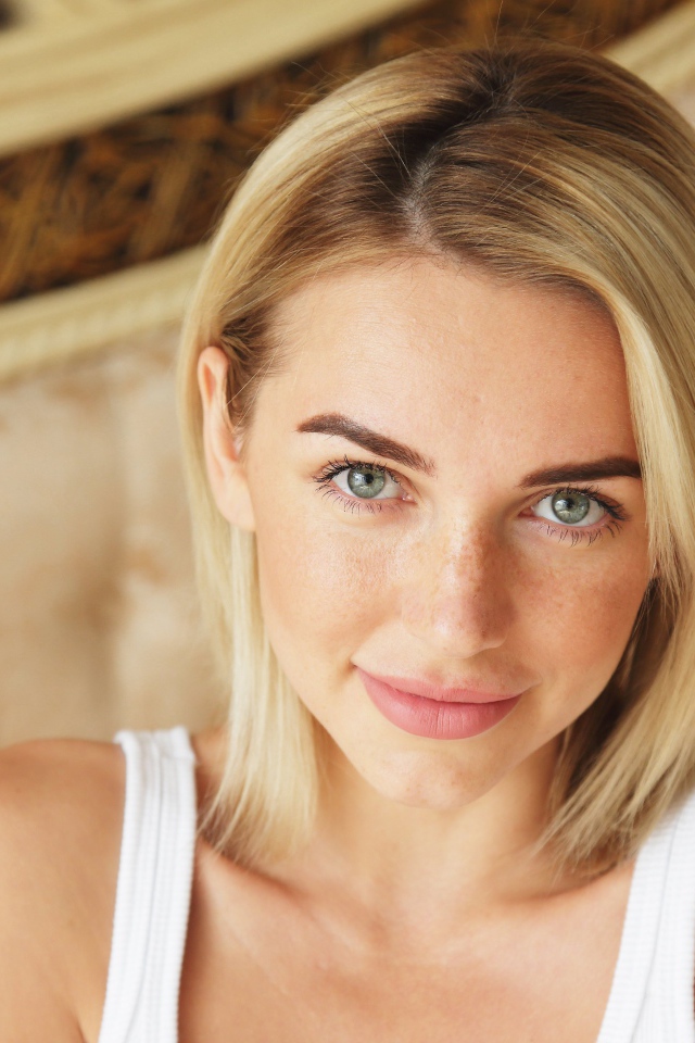 Нежная блондинка с зелеными глазами в белой майке