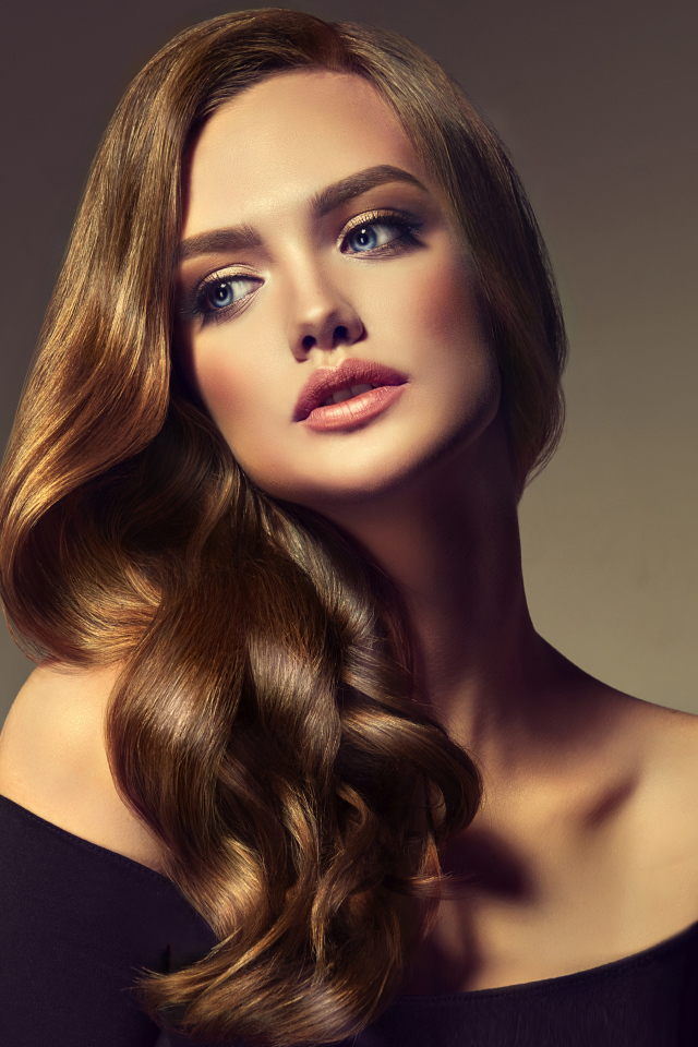 Нежная голубоглазая модель с длинными волосами на сером фоне