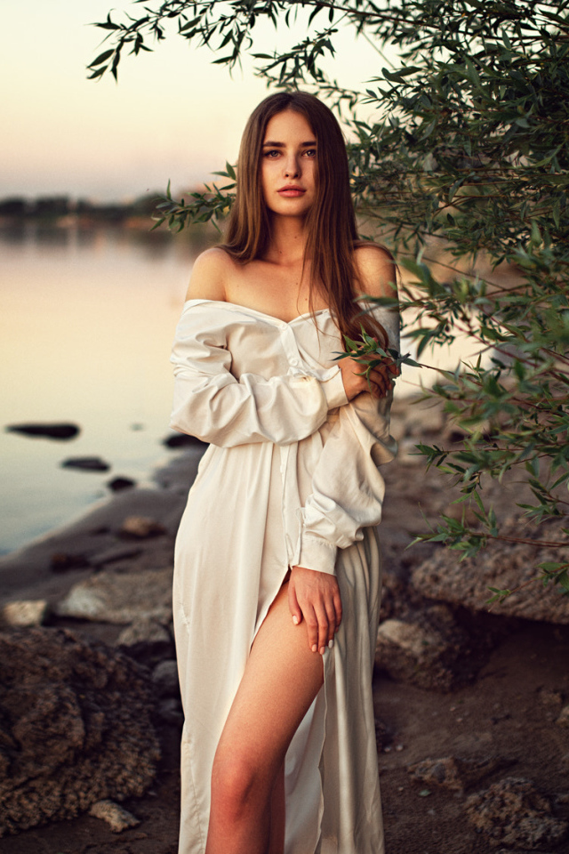 Девушка в красивом белом платье у воды
