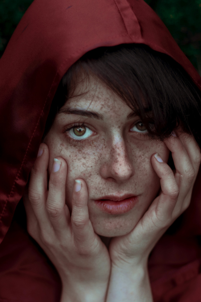 Девушка в красном плаще с веснушками на лице
