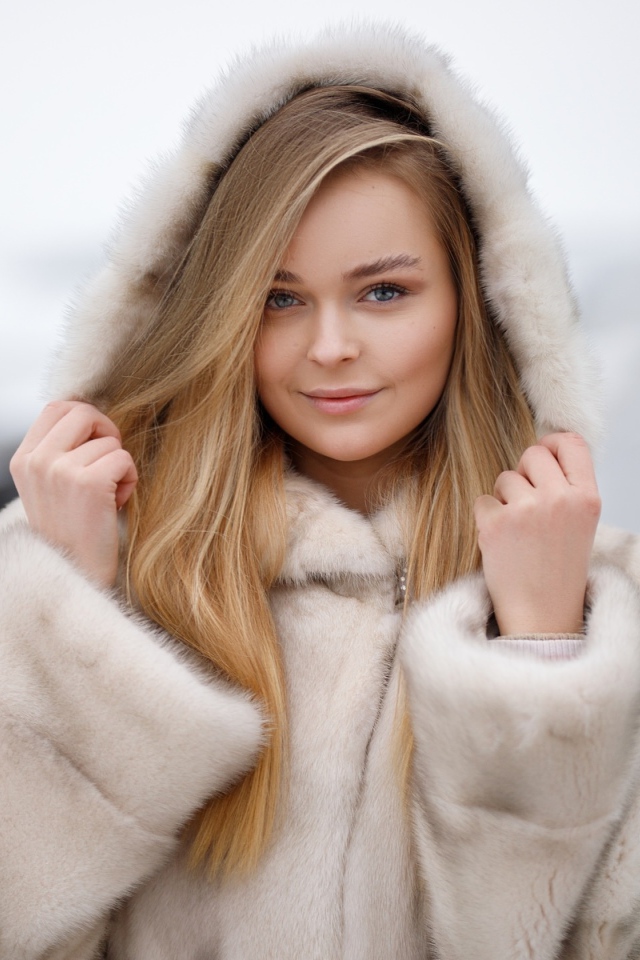 Девушка в теплой шубе на дороге зимой