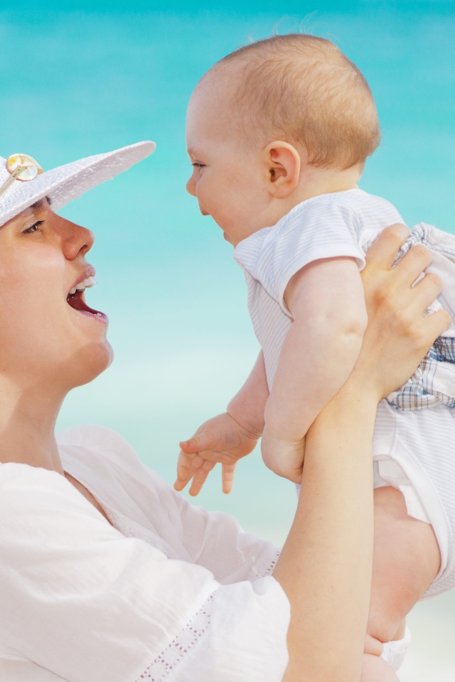 Девушка в белой шляпе с грудным ребенком в руках